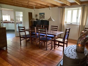 A dining area with wooden furniture, a fireplace, and a view of the kitchen.
