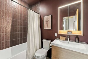 Un bagno con vasca, WC e lavandino.