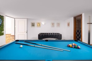A pool table with balls, a foosball table, and a door leading to a bathroom. - Casa Alborán | Jacuzzi | Billiard | BBQ | Sea view (Málaga)