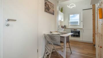A modern kitchen with white cabinets, a built-in oven, and a window above the sink.