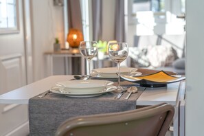 A dining table set with plates, cutlery, and two wine glasses.