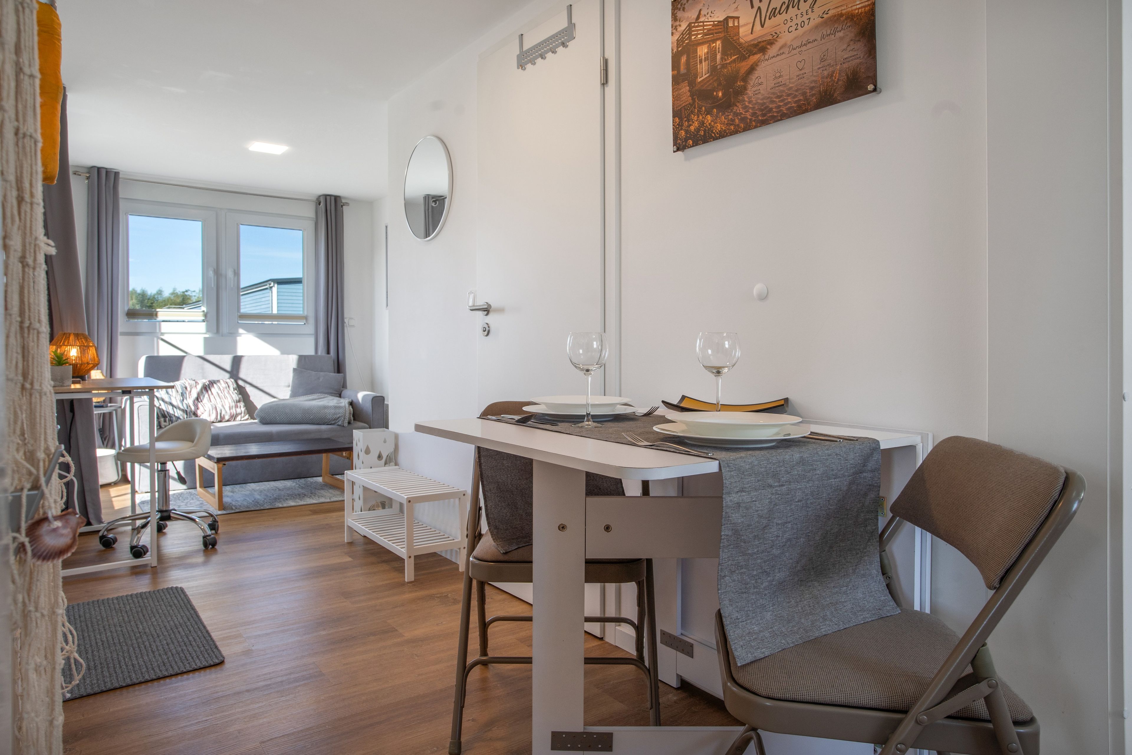 Un espacio habitable compacto con zona de comedor, un sofá, una pequeña mesa y una silla.