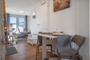 A compact living space with a dining area, a sofa, a small table, and a chair.