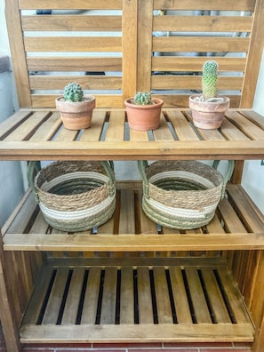 A wooden shelf with three terracotta pots containing cacti and two woven baskets. - Casa Nora (Rosignano Solvay-Castiglioncello)
