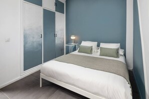 A bedroom with a bed, a nightstand, and a wardrobe. - Villa Botanic | Pool | Ping Pong | Fireplace (Rincon de la victoria)