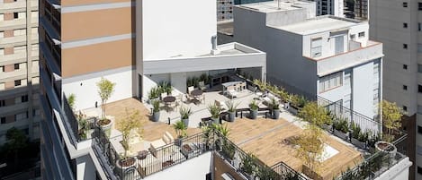 A rooftop terrace with outdoor seating and potted plants.