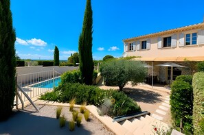A residential property with a swimming pool, a covered outdoor seating area, and a large building with multiple windows. - Holiday home 'Lafintoux' with shared pool, Wi-Fi and air conditioning (Sablet)