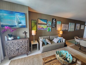 Ein Wohnzimmer mit einer Couch, einem Couchtisch und Kunstwerken an den Wänden.