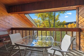 A wooden deck with a glass table and chairs, overlooking a tree-lined view. - NEW LISTING: Top Floor 2 Bed 2 Bath Condo. (Breckenridge)