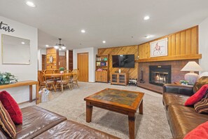 A living room with a fireplace, leather sofas, a coffee table, and a television. - NEW LISTING: Top Floor 2 Bed 2 Bath Condo. (Breckenridge)