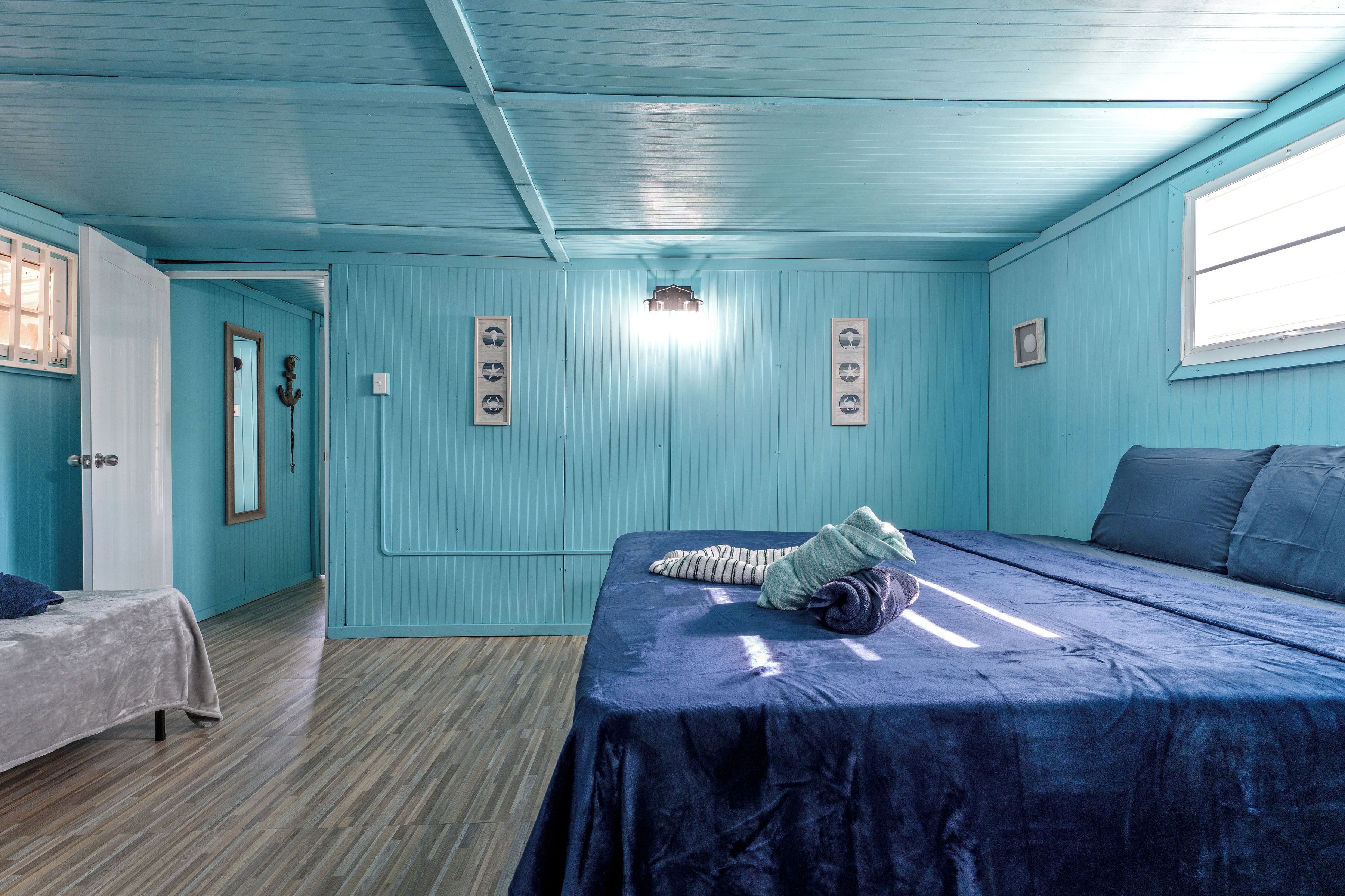 Una habitación con una cama, una mesita y una puerta.