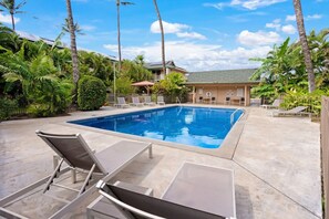 Ein Pool mit Liegestühlen und Palmen.