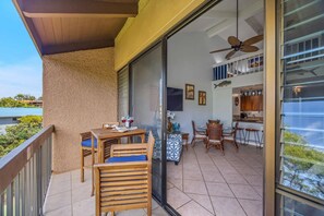 Pour two glasses on the private lanai, treetops and open sky just past the rail. - Maui Vista 2420 by Gather - Kihei Loft Condo w/ Pool, Walk to Kamaole Beaches (Kihei)