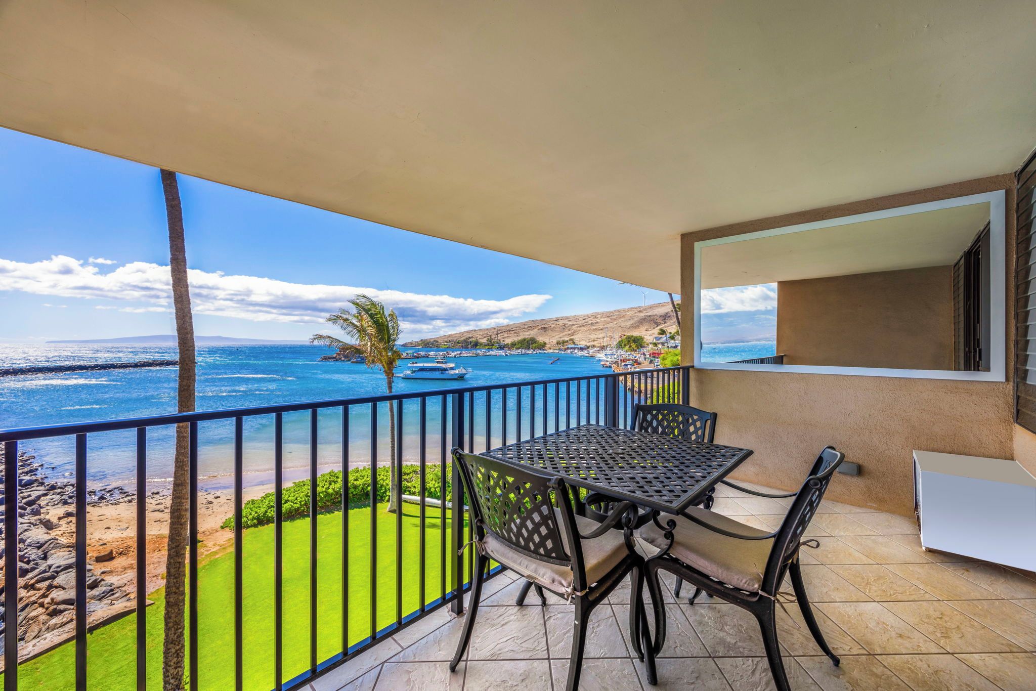 By day the lanai table seats three, with the green lawn and the marina both in view.