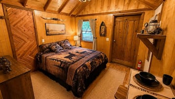 Una habitación acogedora de madera con una cama, un escritorio y una ventana.