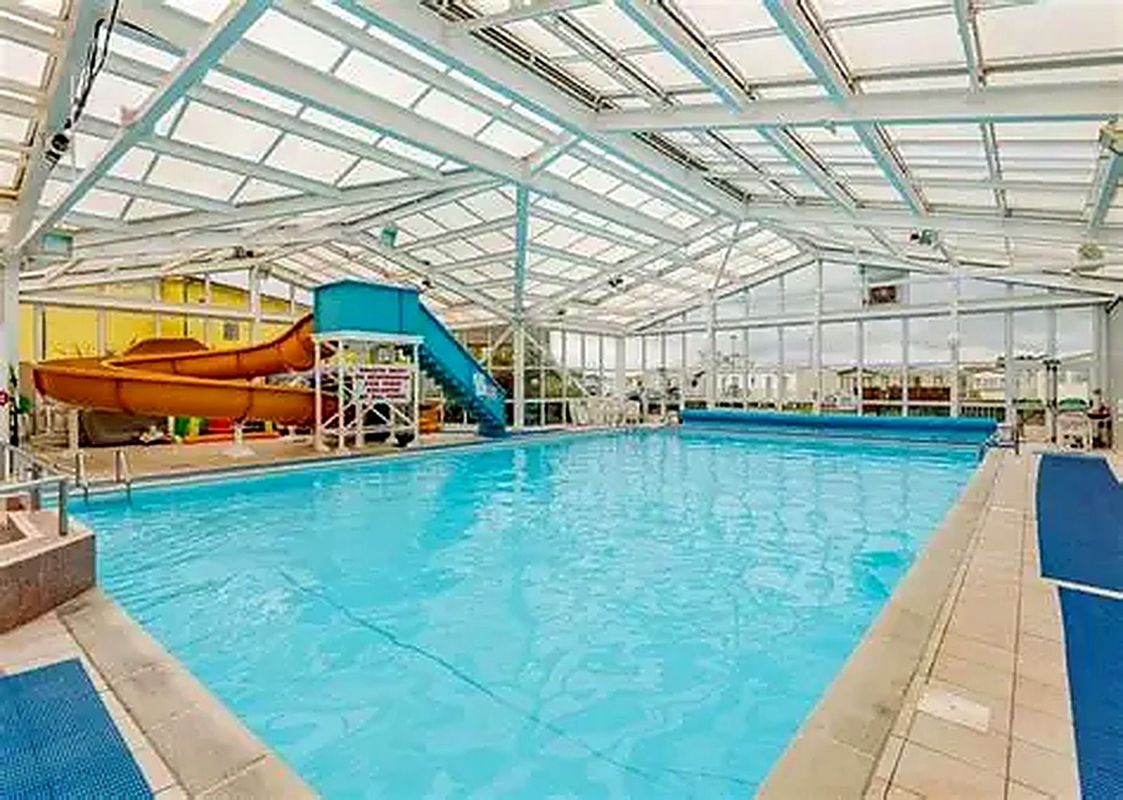 An indoor swimming pool with a slide and diving platforms.