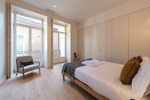 Une chambre à coucher avec un lit, une chaise, un balcon et une armoire.