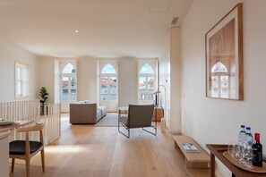 Ein modernes Interieur mit Essbereich, Sitzgelegenheiten und Blick durch bogenförmige Fenster.