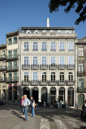 Un bâtiment historique à la façade symétrique, doté de nombreuses fenêtres et de balcons richement décorés.