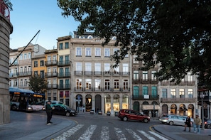 A street with historic buildings, a bus, and cars. - Tripas-Coração: Mouzinho32 1st Floor Apt E (Porto)