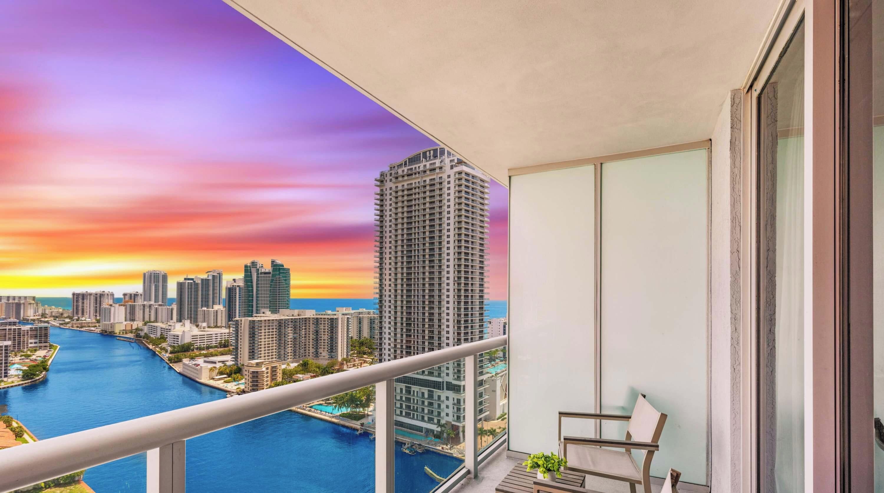 A balcony with a view of a city skyline and a river.