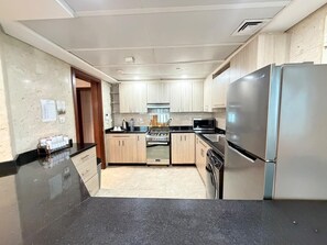 A kitchen with a stove, oven, refrigerator, and dishwasher. - VESTA  -  Executive Suite - 2BR - Nile View (Cairo)