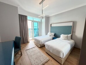 A hotel room with two beds, a desk, and a view of the outdoors. - VESTA  -  Executive Suite - 2BR - Nile View (Cairo)