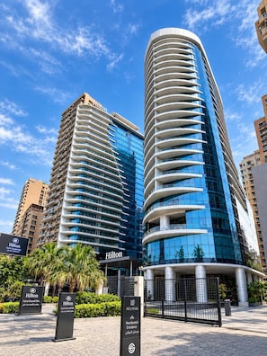 Two high-rise hotels with a clear sky, one with a curved facade and the other with a straight facade, both featuring the Hilton logo. - VESTA  -  Executive Suite - 2BR - Nile View (Cairo)