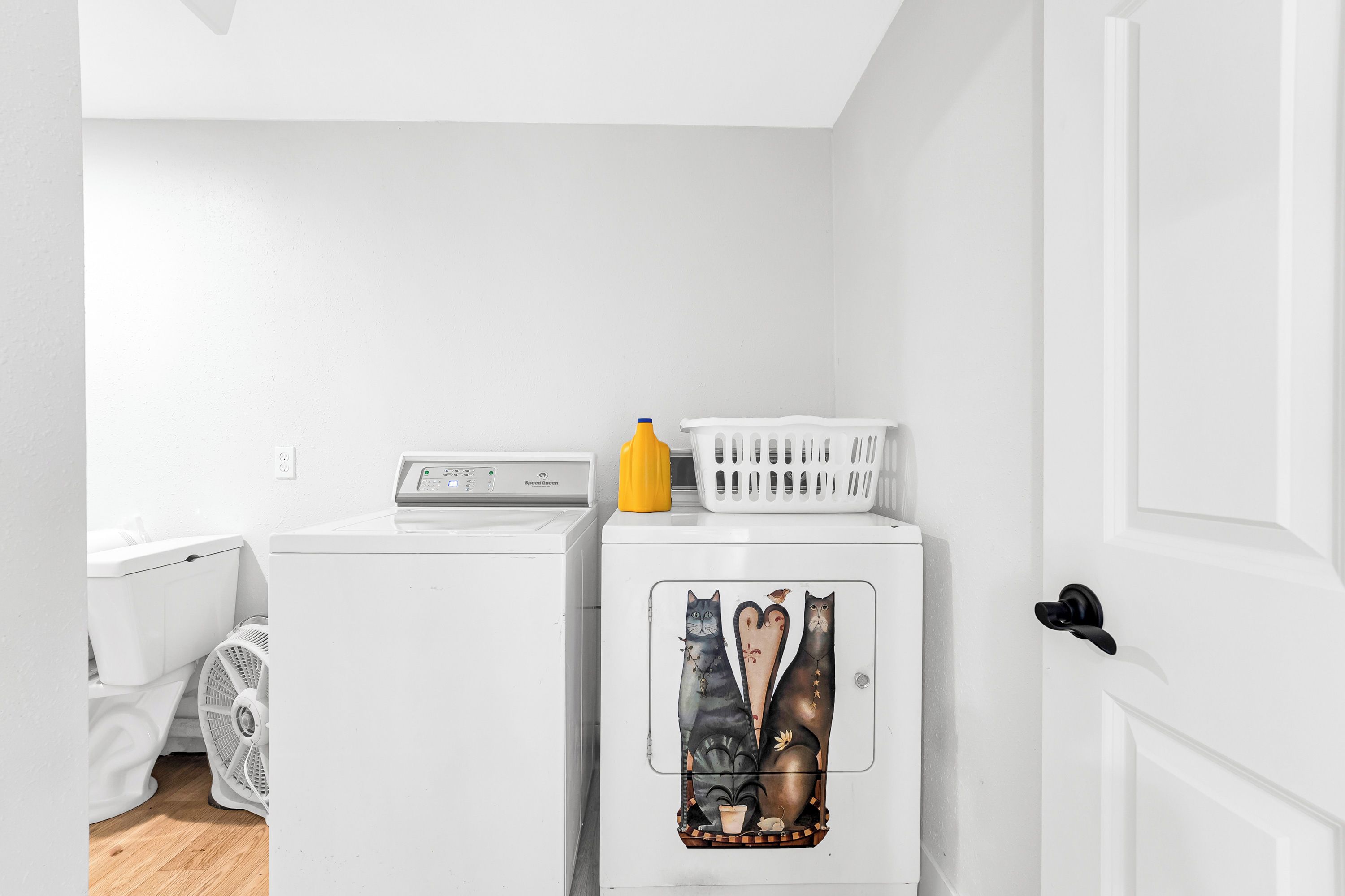 A laundry room with a washing machine, dryer, and stacked laundry baskets.