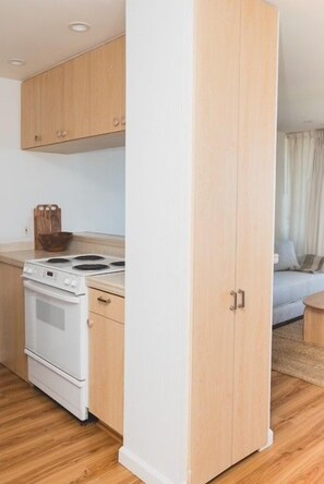 Eine Küche mit Holzausstattung, einem Herd und einem Essbereich mit einer Couch.