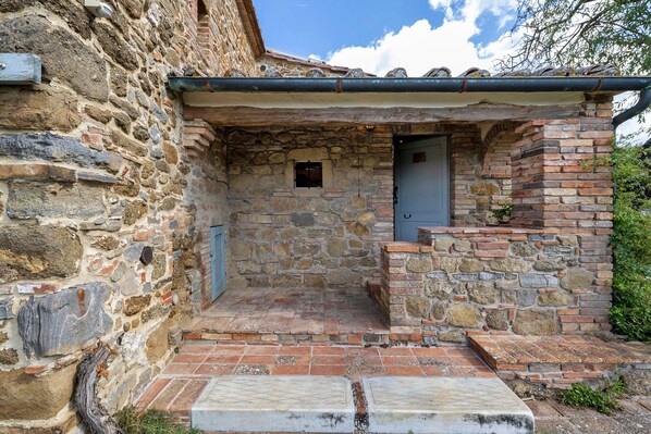 A stone building with a small entrance and a door.