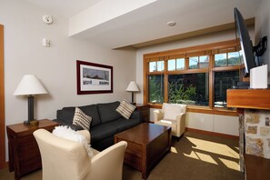 A modern living room with a sofa, armchairs, a coffee table, and a TV. - Luxury 2 Bed, 2 Bath, Capitol Peak, In the heart of Base Village, steps to lift! (Snowmass Village)