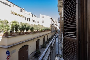 Eine schmale Gasse mit Häusern an beiden Seiten, einem Fußweg und einem heruntergelassenen Rollo auf der rechten Seite.