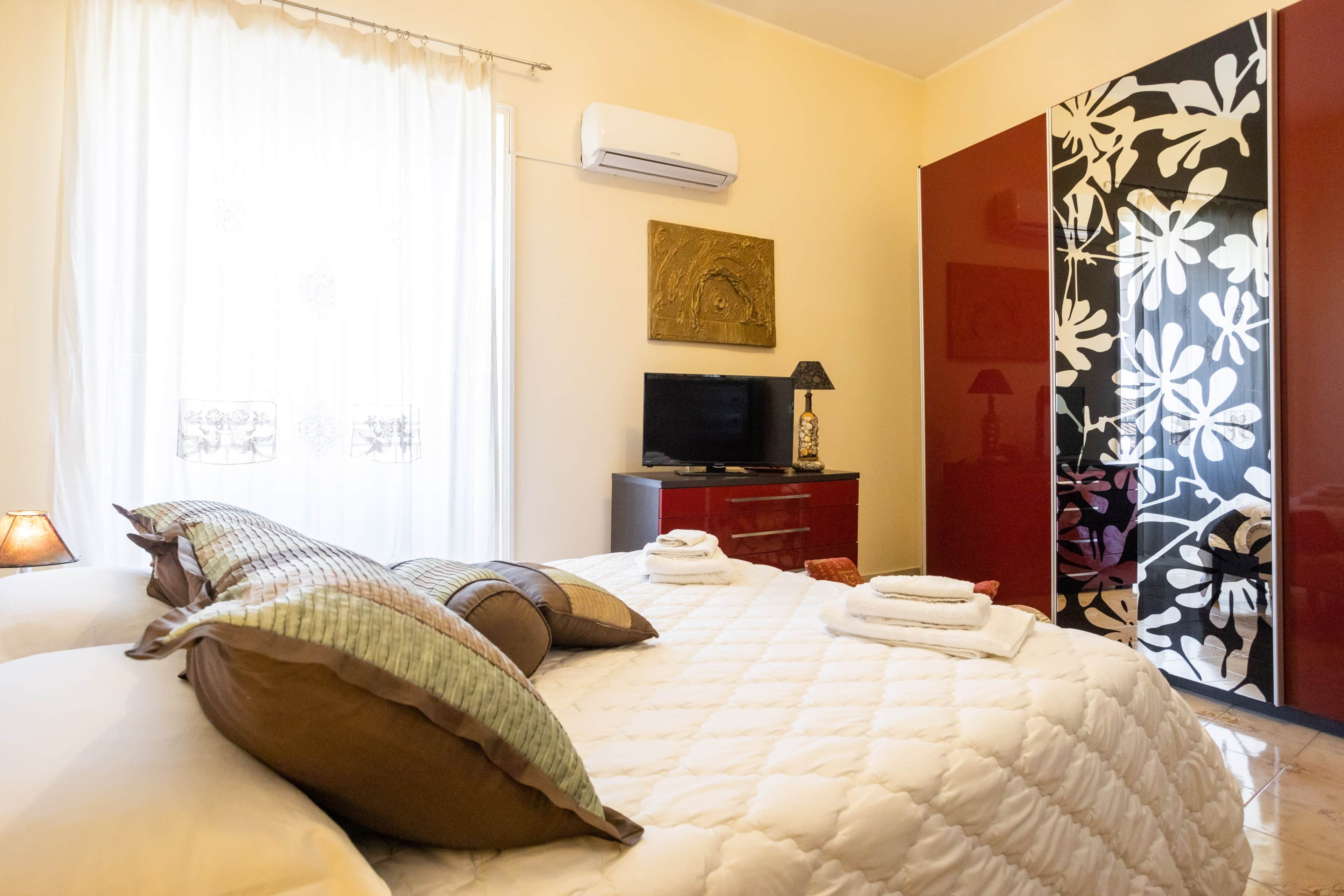 Une chambre d’hôtel comprenant un lit, une télévision, un bureau avec une lampe et une armoire.
