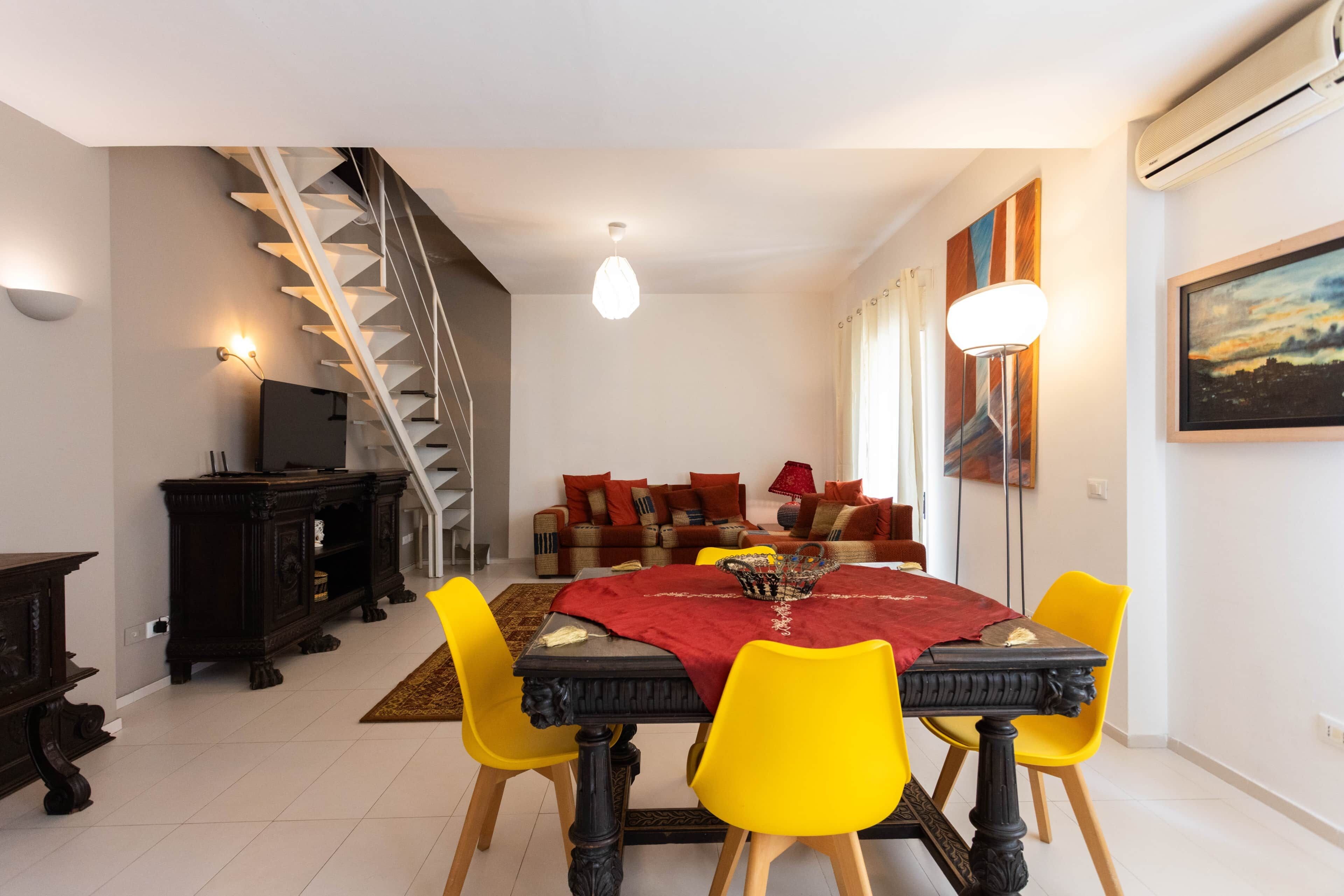 Un espace repas comprenant une table, des chaises et un escalier.