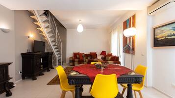 Un espace repas comprenant une table, des chaises et un escalier.