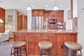 A kitchen with wooden cabinets, stainless steel appliances, and a granite countertop. - Lake and Mountain Views. Center Village Gem. In unit washer and dryer! Steps fro (Copper Mountain)