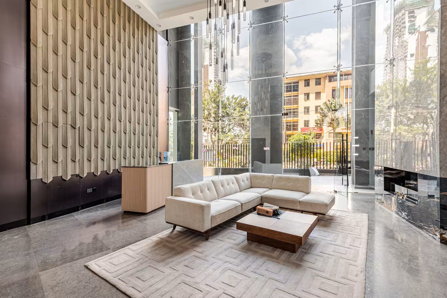 Una sala moderna con un sofá modular, una mesa de centro y una alfombra estampada.