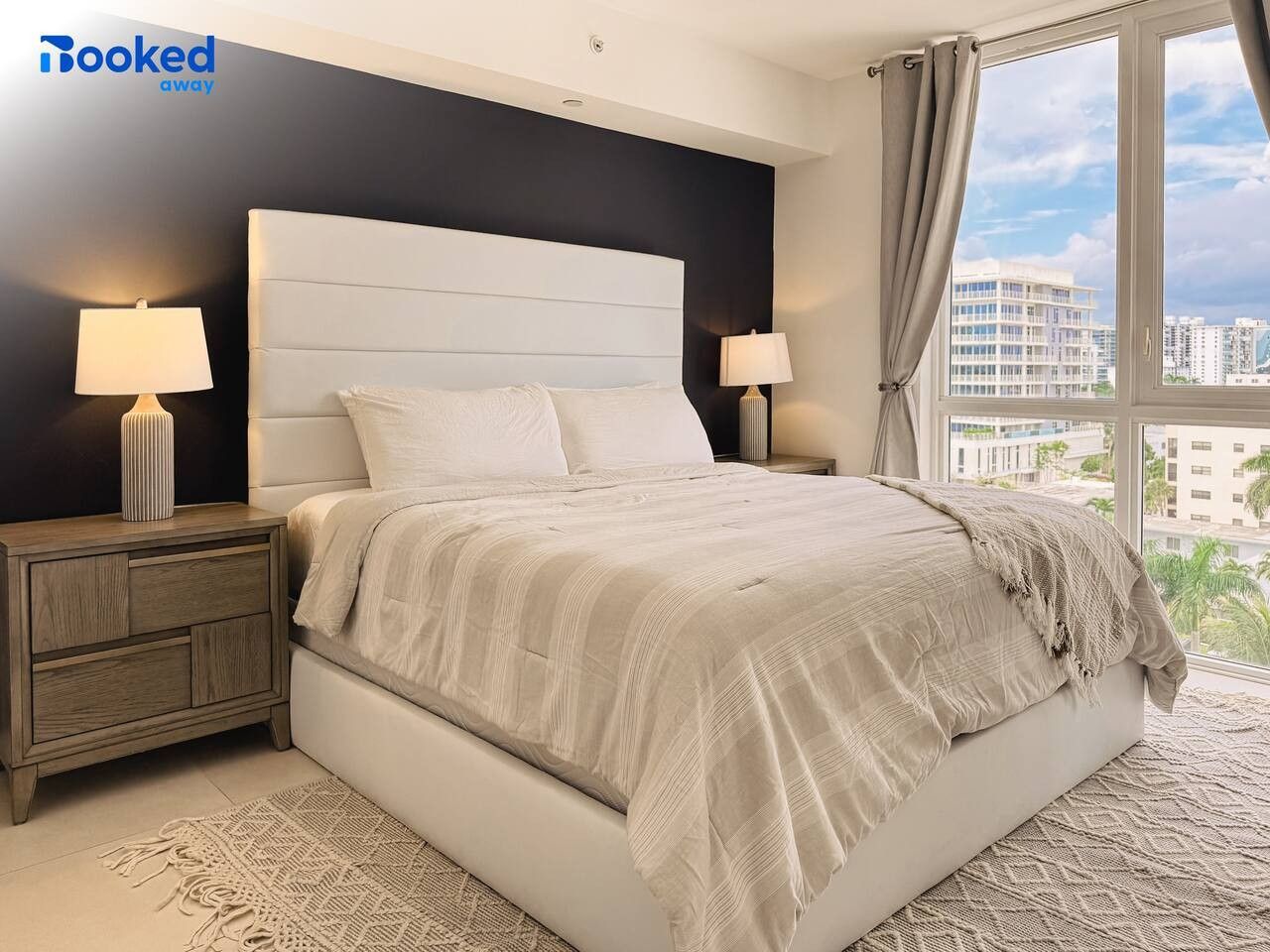 Rest easy in your luxurious bedroom retreat, featuring a plush king-sized bed, soft neutral tones, elegant bedside lighting, and expansive windows framing the Fort Lauderdale skyline.