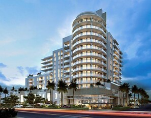 Un hôtel à plusieurs étages, doté d’une façade incurvée, de balcons et d’un espace paysager agrémenté de palmiers.