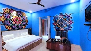 A bedroom with a bed, a desk, and two large wall art pieces.