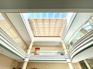 A multi-level atrium with a glass ceiling, columns, and a central staircase. - Central Granada Apartment for 4 (Granada)