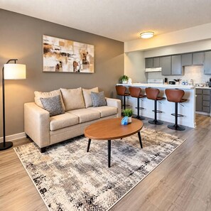 A living room with a sofa, a coffee table, and a patterned rug. - Modern Tempe 1BR Retreat | Near ASU & Downtown (Tempe)