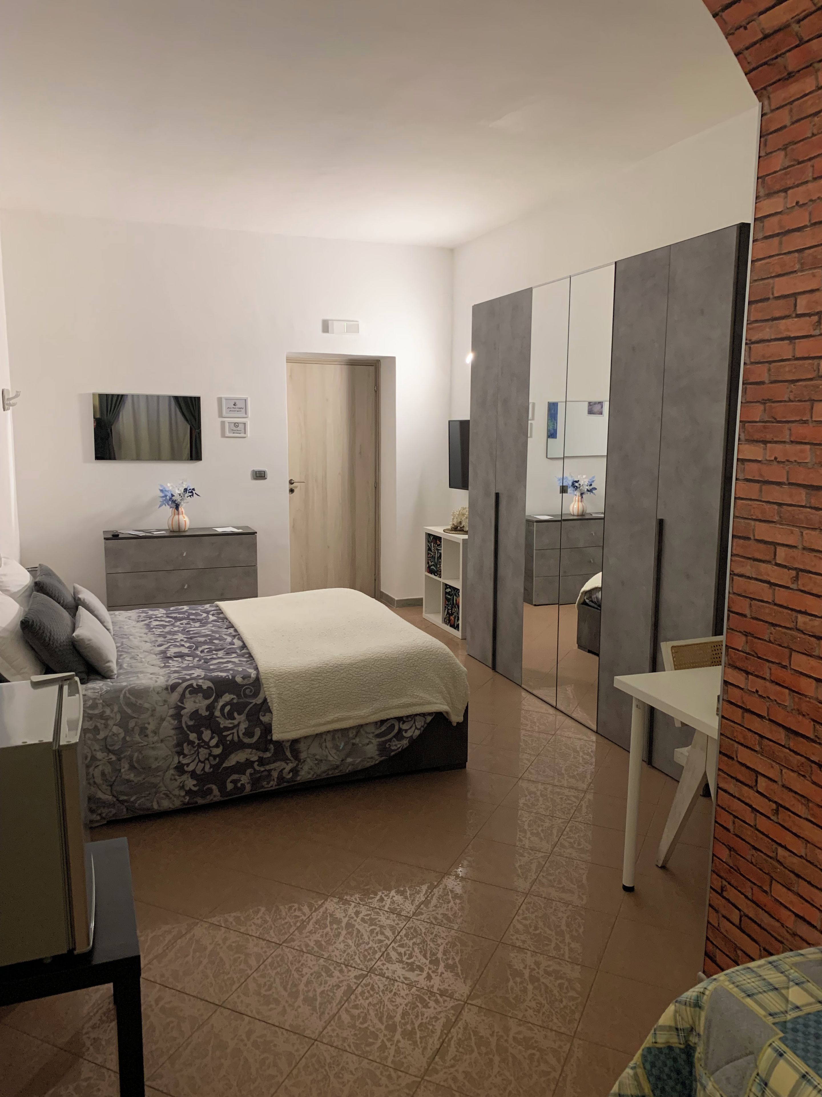 Une chambre à coucher moderne avec un lit, une commode et un grand miroir.