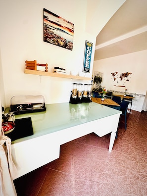 Una cocina moderna con una mesa de vidrio, estantes de madera y un mapa mundial en la pared.