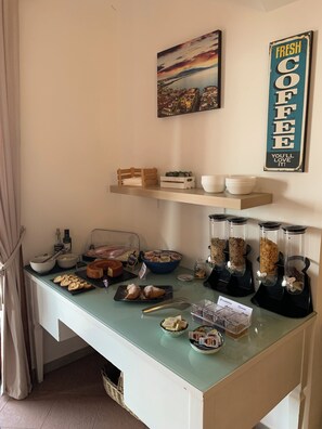 A breakfast buffet setup with various food items and a coffee station.