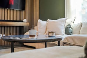 A cozy living room with a round coffee table, a white mug, and a small basket. - Lake Cumberland Farmhouse: Arcade Room, Fire Pit, Boat Parking, Pet Friendly (Russell Springs)