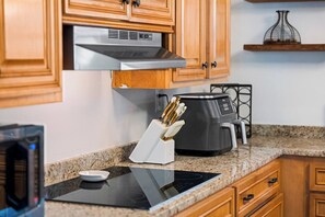 A kitchen with wooden cabinets, a stainless steel range hood, a coffee maker, and a knife block. - Lake Cumberland Farmhouse: Arcade Room, Fire Pit, Boat Parking, Pet Friendly (Russell Springs)