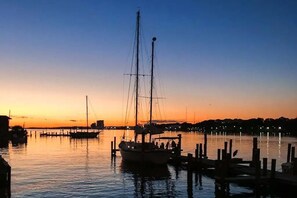 A marina at dusk with boats docked, calm water, and a clear sky. - 🎣 Palm Court Yacht Club 312B | Waterfront Views, Pool & Fishing Dock 🌊 (Fort Walton Beach)
