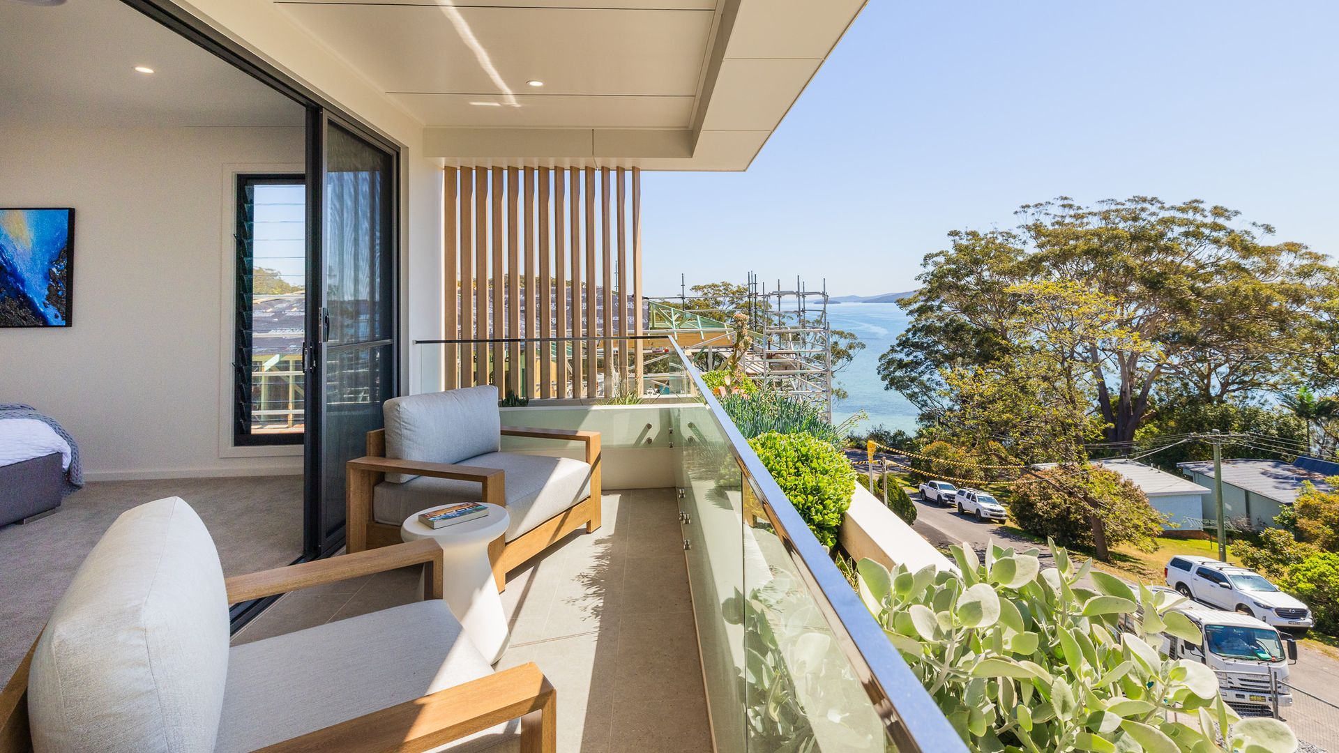 A balcony with a view of the sea, a sofa, and a dining table.